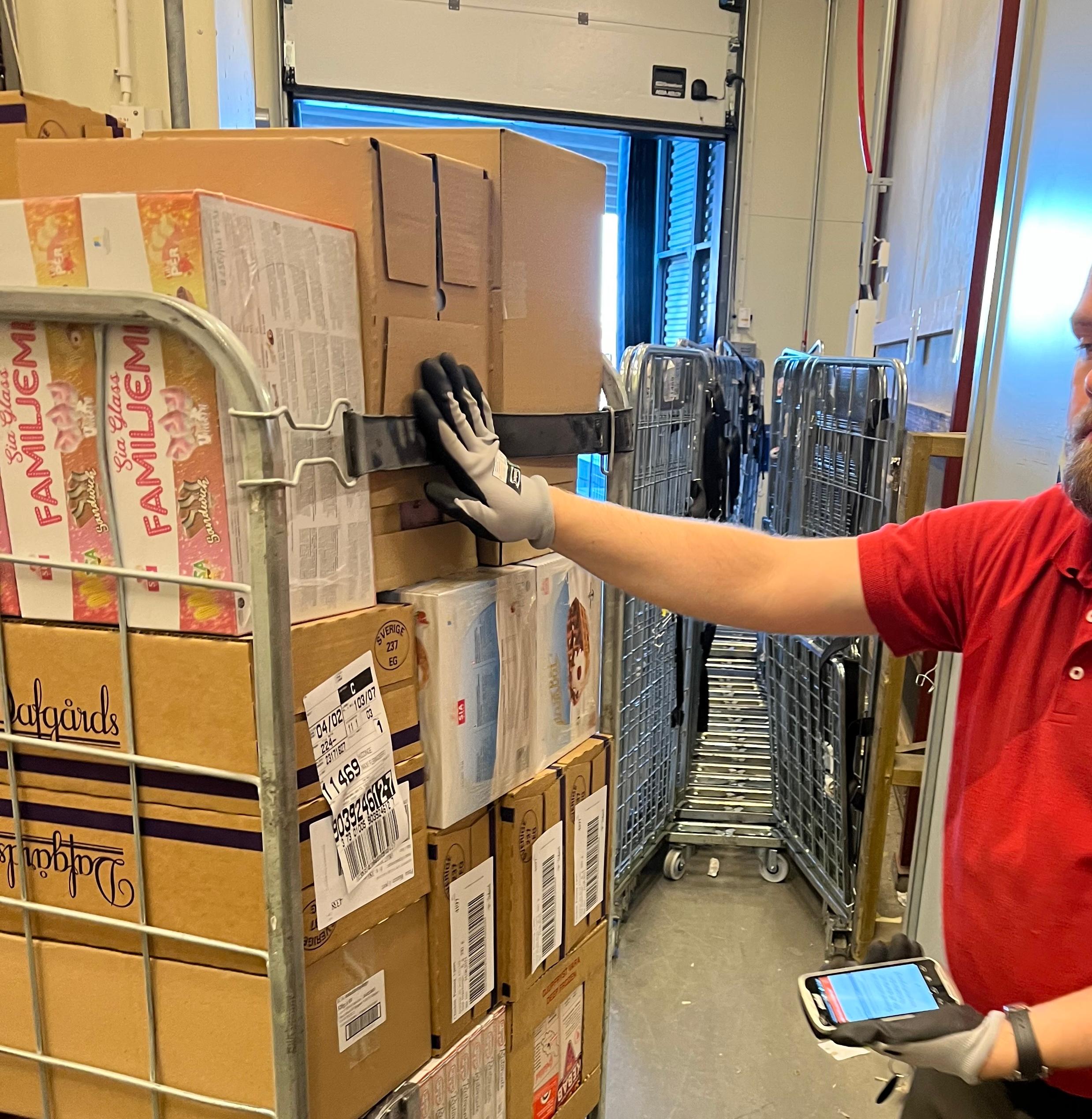 Warehouse worker scans packages with a handheld device.
