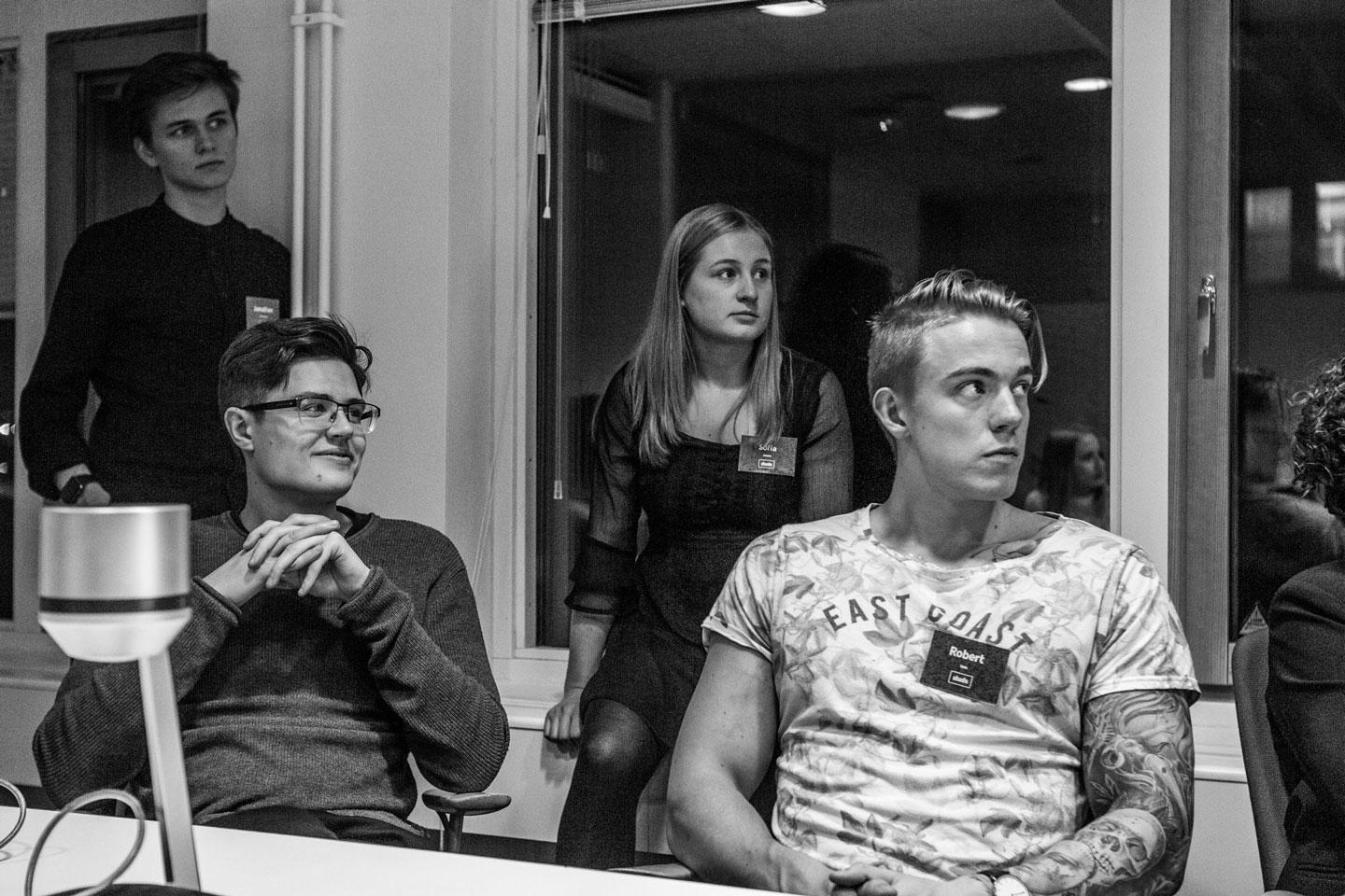 Group of people of various ages looking attentively in the same direction in a meeting room.